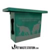 A green pet waste station box with silhouettes of two dogs sniffing the ground. Text reads: "For the safety of the dogs, please pick up waste completely & promptly." Pet Waste Station branding is at the bottom.