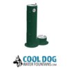 A green outdoor water fountain with a tall spout for people and a lower bowl for dogs, shown above the "Cool Dog Water Fountains.com" logo featuring a dog illustration.