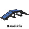 A black and blue dog agility ramp with two ramps leading up to a flat platform, shown on a white background. Text below reads "Play & Agility Powered by GYMS FOR DOGS.COM.