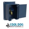 A blue outdoor water spigot in a wall-mounted box with an open door, showing a brass valve. Below is a logo with a dog illustration and the text "COOL DOG WATER FOUNTAINS.COM".