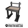 A sturdy black dog agility table with a wooden top, labeled "DOGTASTICFOR DOGS," and the text "Play & Agility Powered by Gyms For Dogs.com" with a paw print below.