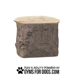 The Natural Jumping Stump - Large is a wooden platform resembling a tree stump, labeled "GYMS FOR DOGS Natural Dog Park Products" with "PLAY & AGILITY POWERED BY GYMSFORDOGS.COM" below.