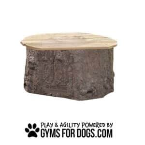 A small dog agility platform called the Natural Jumping Stump features a wooden top shaped like a tree stump. Below, text reads "Play & Agility Powered by GymsForDogs.com" with a paw print graphic.