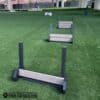 A set of three Jump Hurdle Run hurdles for dogs is arranged on artificial grass at an outdoor park. The front hurdle displays “DOGS ONLY,” creating a clean, inviting space for dogs to exercise and have fun.