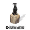 A black dog sits on the Lumber Mill, a realistic artificial tree stump with "Play & Agility Powered by GymsForDogs.com" and a paw print logo below.